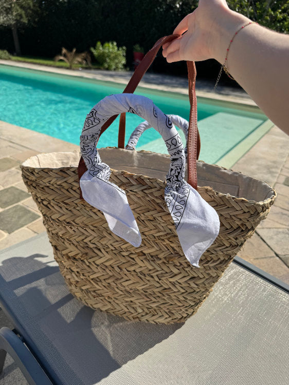 Straw beach bag with bandana on the handles