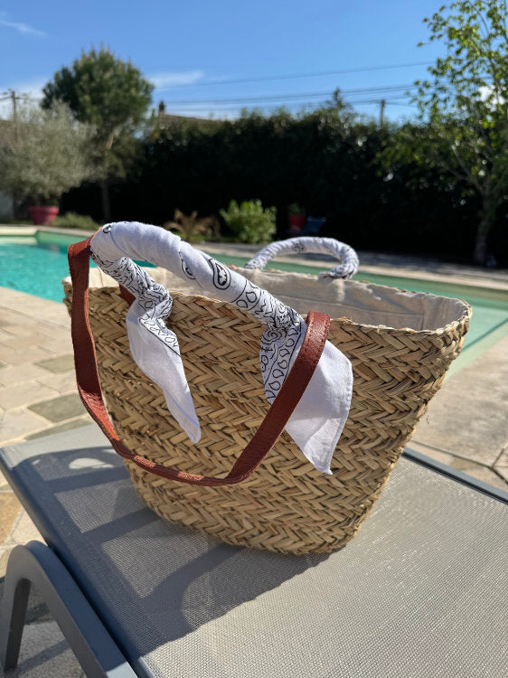 Straw beach bag with bandana on the handles